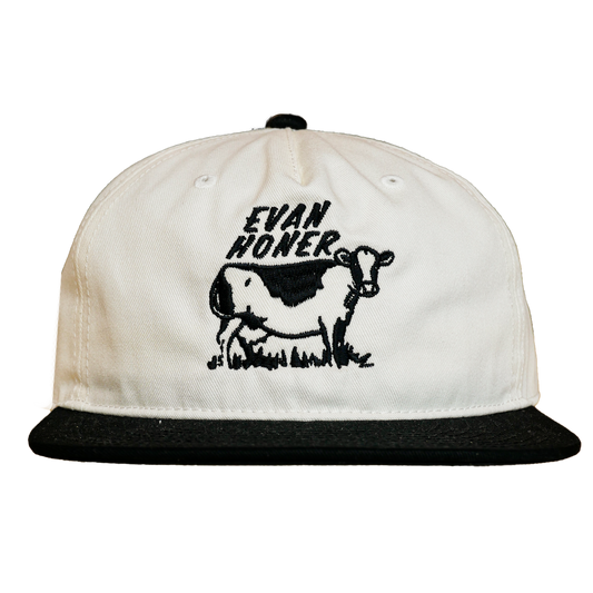 White cap with black cow graphic and 'Evan Hower' text on a white background