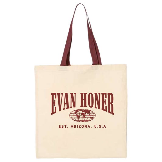 Beige tote bag with 'Evan Honer' text and logo on a white background